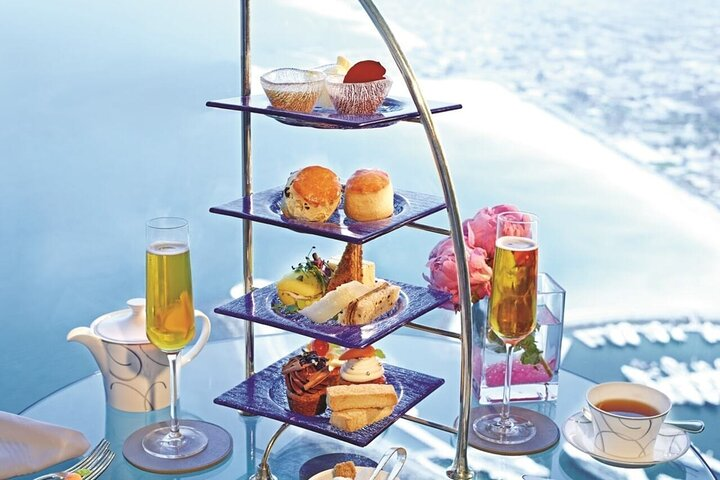 Indulge in a delightful afternoon of high tea at Burj Al Arab surrounded by stunning views and exquisite treats all while enjoying live piano melodies in a luxurious setting.